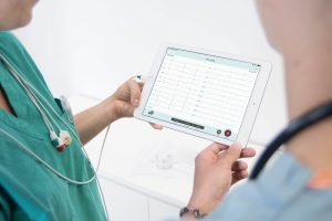 A doctor and a nurse discussing the ECG watching iPad screen